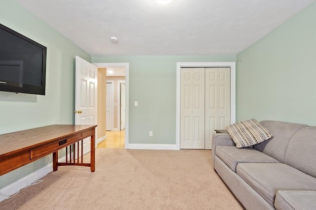 living area featuring light colored carpet and baseboards