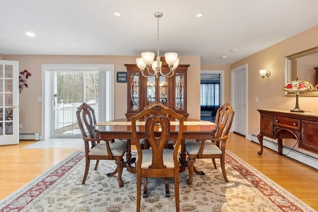 dining space featuring recessed lighting, light wood-style flooring, a baseboard heating unit, and an inviting chandelier