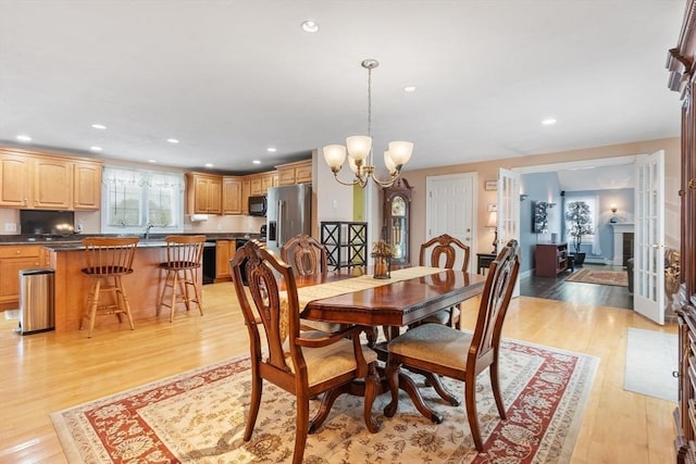 dining space featuring recessed lighting, an inviting chandelier, and light wood-style flooring