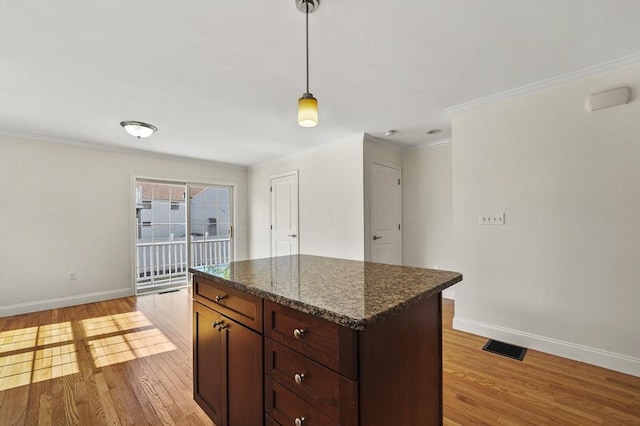 8 School St Unit 1, Waltham, MA 02452 - kitchen featuring baseboards, light wood-type flooring, ornamental molding, a center island, and decorative light fixtures