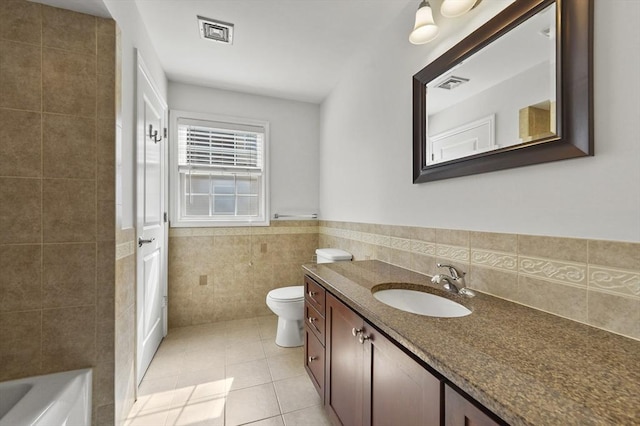 8 School St Unit 1, Waltham, MA 02452 - bathroom featuring tile walls, vanity, tile patterned flooring, toilet, and a wainscoted wall
