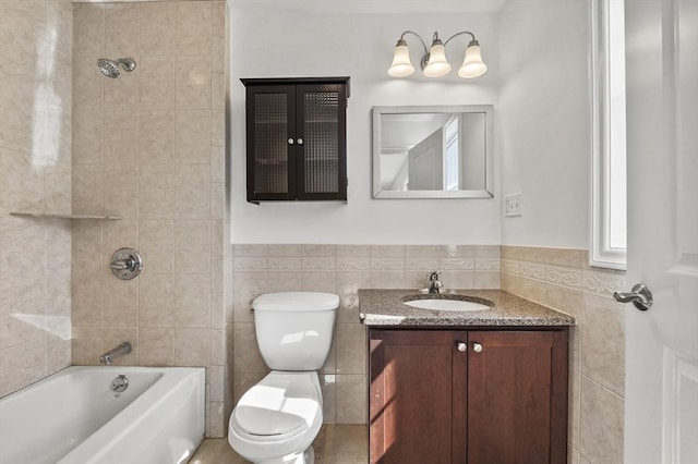 8 School St Unit 1, Waltham, MA 02452 - bathroom featuring tile walls, toilet, vanity,  shower combination, and wainscoting