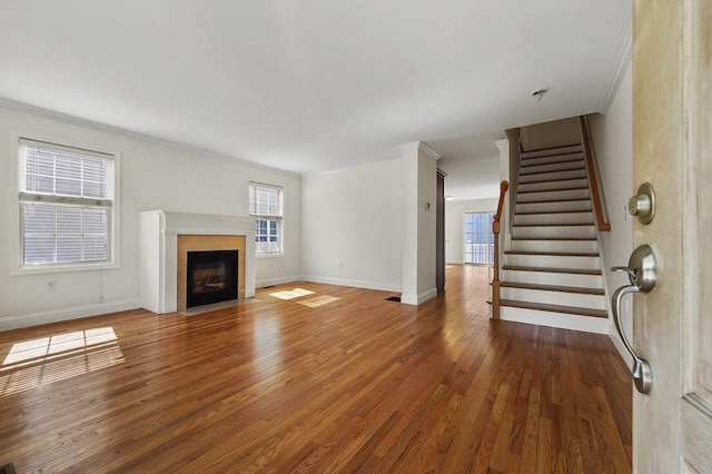8 School St Unit 1, Waltham, MA 02452 - unfurnished living room with ornamental molding, wood finished floors, stairway, a fireplace with flush hearth, and baseboards