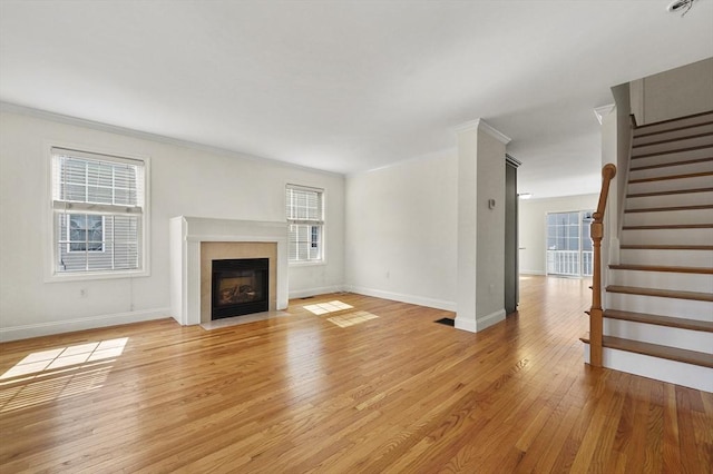 8 School St Unit 1, Waltham, MA 02452 - unfurnished living room featuring light wood-style floors, baseboards, a fireplace with flush hearth, stairs, and ornamental molding
