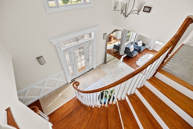 entryway with a high ceiling, a notable chandelier, and hardwood / wood-style floors