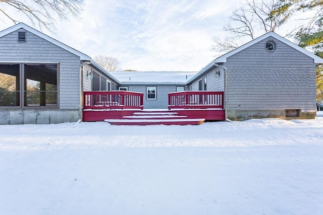 snow covered rear of property featuring a deck