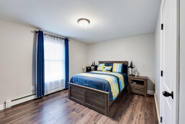 bedroom with a baseboard heating unit, baseboards, and wood finished floors