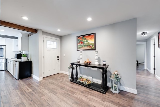 entryway featuring beamed ceiling, recessed lighting, light wood-style flooring, and baseboards