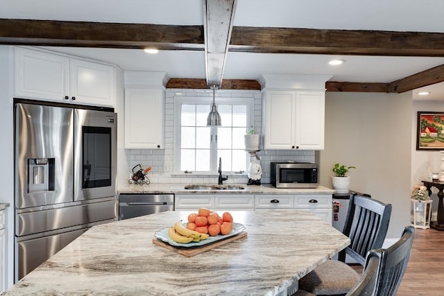 kitchen featuring a sink, white cabinetry, backsplash, and stainless steel appliances