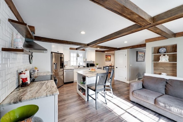 kitchen with open shelves, appliances with stainless steel finishes, wood finished floors, and a sink