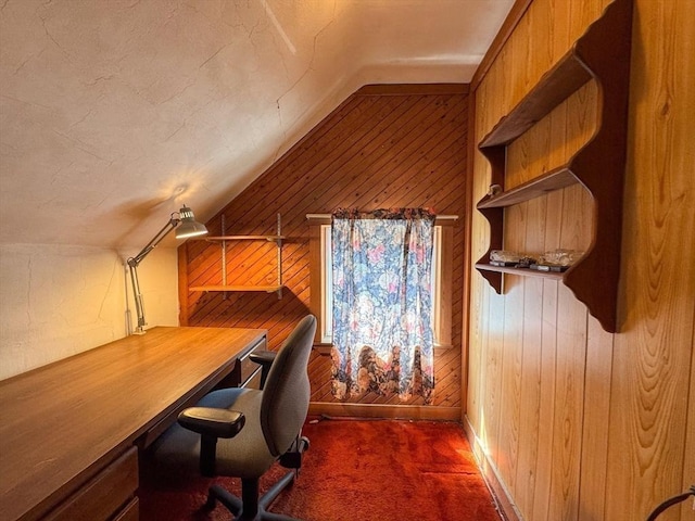 carpeted office space featuring lofted ceiling and wooden walls