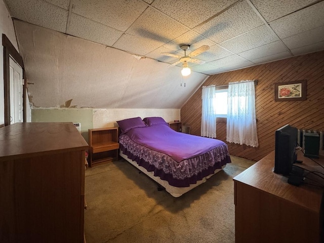 carpeted bedroom with wooden walls, ceiling fan, and lofted ceiling