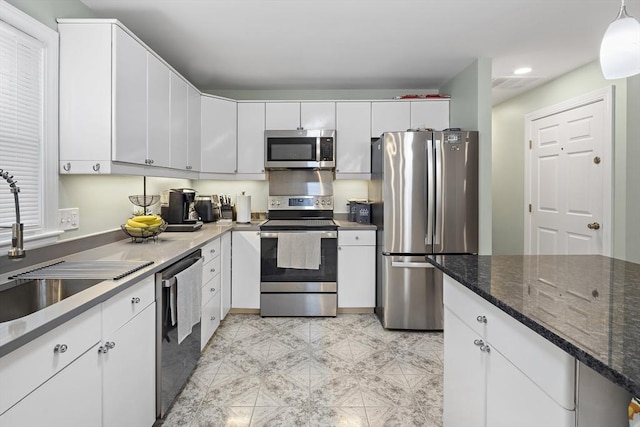 kitchen with white cabinetry, pendant lighting, stainless steel appliances, and sink