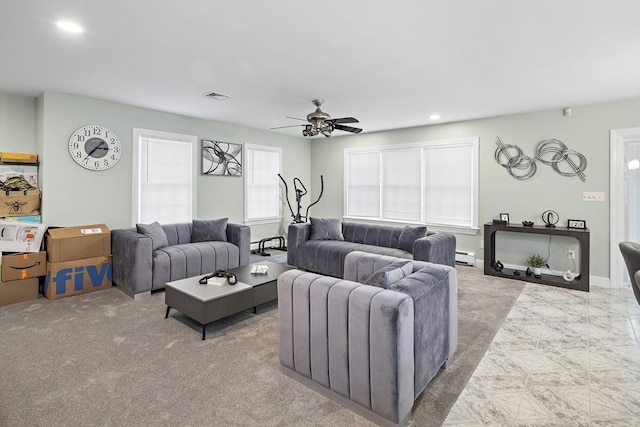 carpeted living room with ceiling fan and a baseboard heating unit