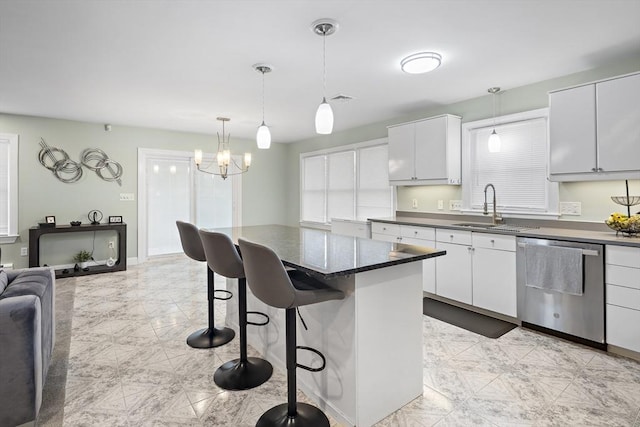 kitchen featuring dishwasher, white cabinets, sink, hanging light fixtures, and a kitchen bar