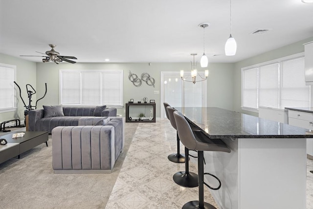 living room featuring ceiling fan with notable chandelier