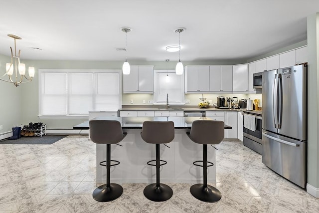 kitchen with hanging light fixtures, white cabinets, stainless steel appliances, and a notable chandelier