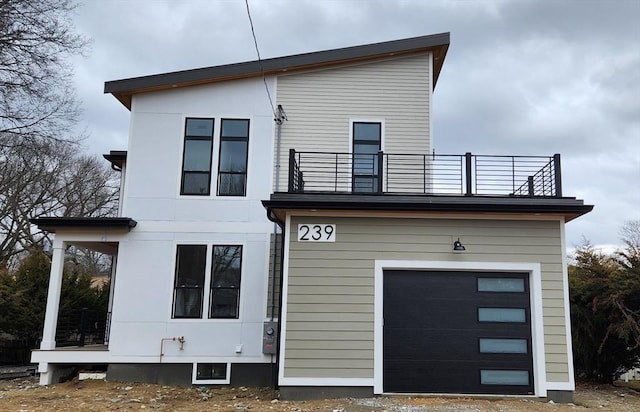 view of front of property with a garage and a balcony