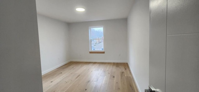 empty room with light wood finished floors and baseboards