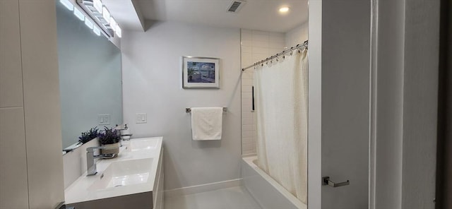 full bath with shower / tub combo, a sink, visible vents, baseboards, and double vanity