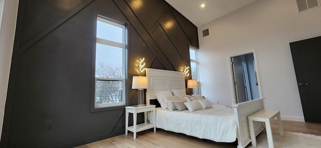 bedroom with light wood finished floors, baseboards, and visible vents