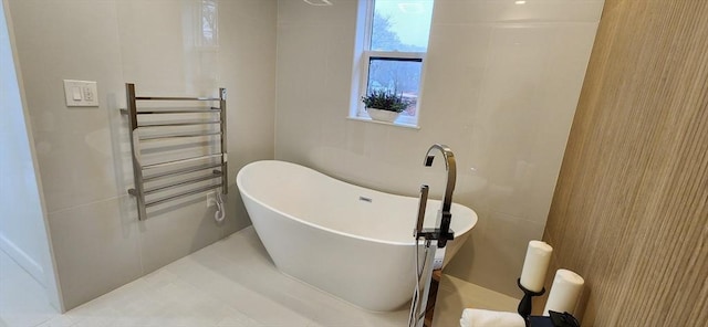 bathroom with radiator and a freestanding bath