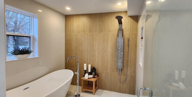 full bathroom with a shower with door, a freestanding bath, tile walls, and recessed lighting