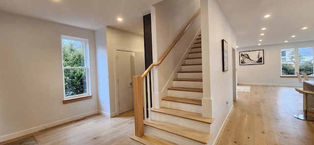 stairs featuring plenty of natural light, wood finished floors, and recessed lighting