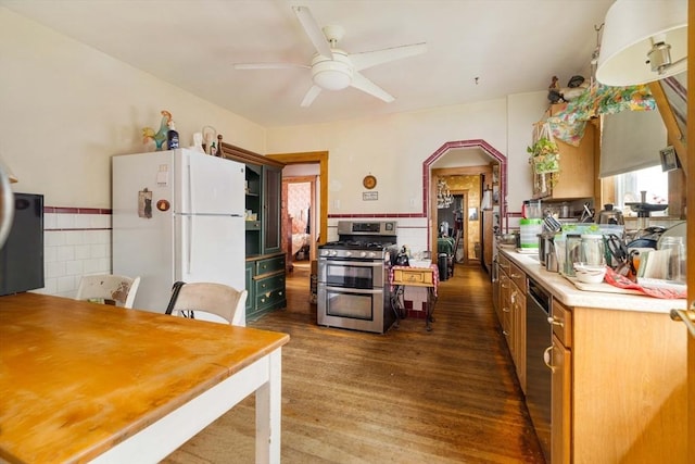 kitchen with appliances with stainless steel finishes, dark wood-style flooring, ceiling fan, and light countertops