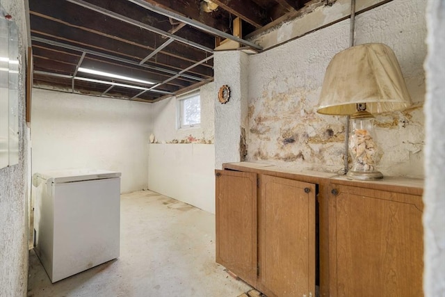 below grade area featuring refrigerator