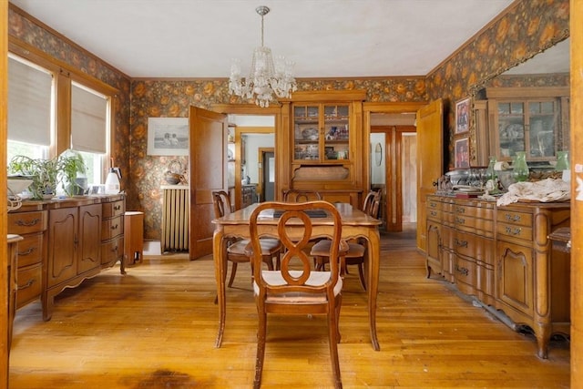 dining area with wallpapered walls, a chandelier, and light wood-type flooring
