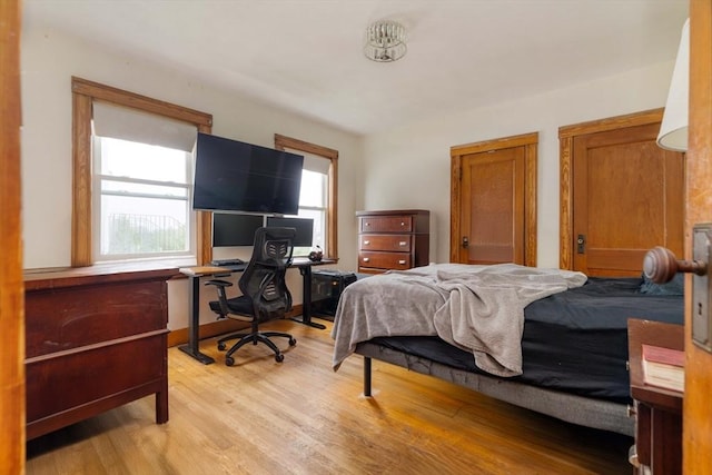bedroom featuring light wood-style flooring and a desk