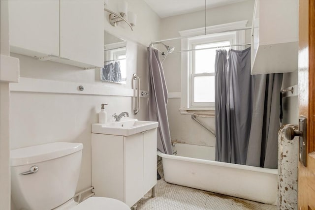 bathroom featuring toilet, shower / bathtub combination with curtain, and vanity