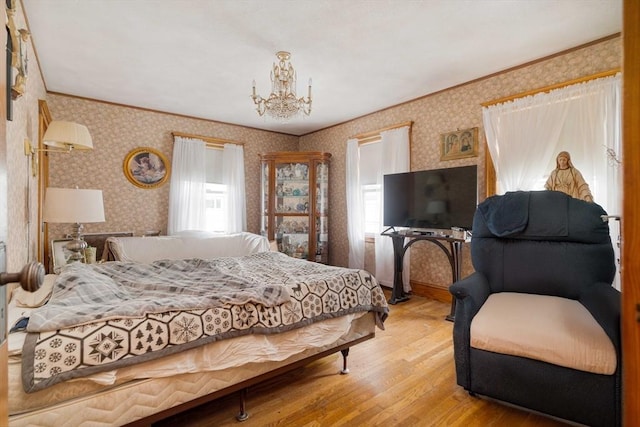 bedroom with wallpapered walls, wood finished floors, crown molding, and a chandelier