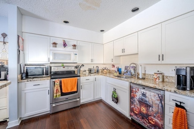 kitchen featuring stainless steel appliances, dark wood-style flooring, a sink, and white cabinetry