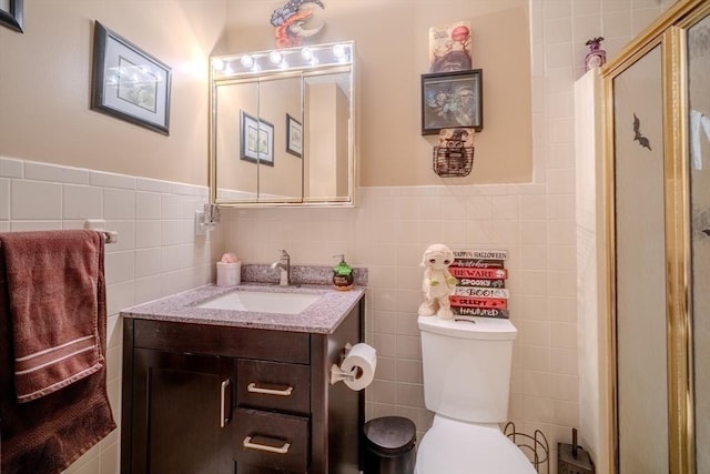 full bathroom featuring toilet, a stall shower, tile walls, and vanity