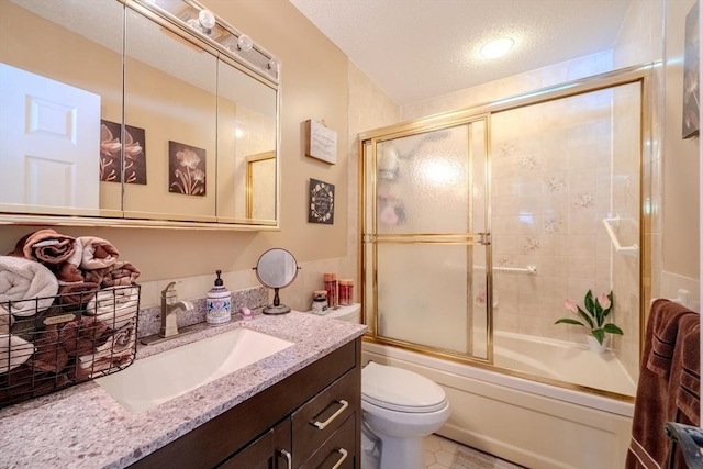 full bathroom with a textured ceiling, combined bath / shower with glass door, vanity, and toilet