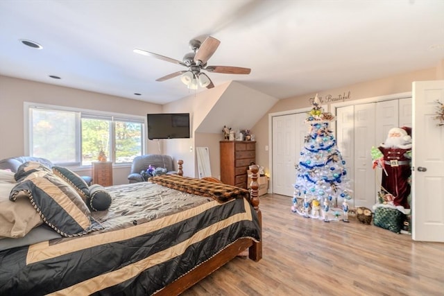 bedroom featuring two closets, ceiling fan, and wood finished floors