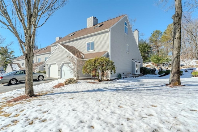 view of snowy exterior featuring a chimney