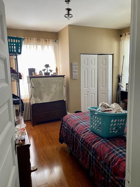 257 French St, Fall River, MA 02720 - bedroom with wood finished floors, radiator heating unit, and a closet