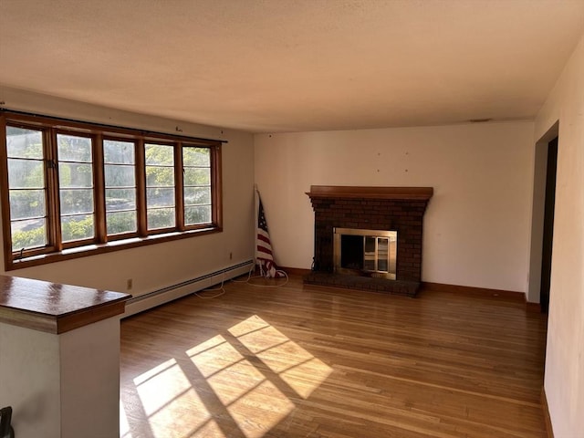 14 Rogers Cir, Braintree, MA 02184 - unfurnished living room with a baseboard heating unit, wood finished floors, a fireplace, and baseboards