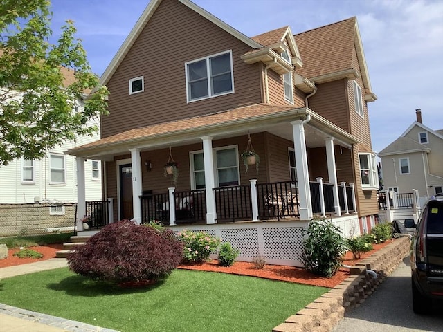 11 Dyer, Everett, MA 02149 - view of front facade featuring a porch, a shingled roof, and a front lawn