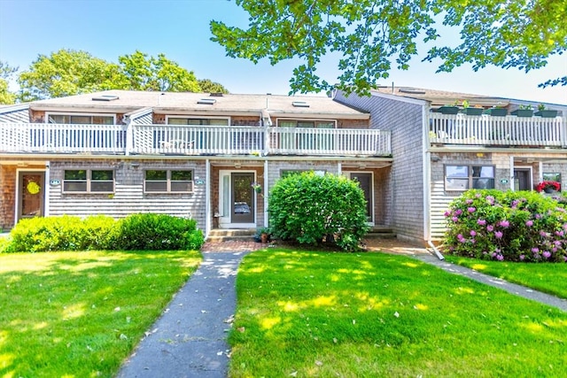townhome / multi-family property featuring a front lawn