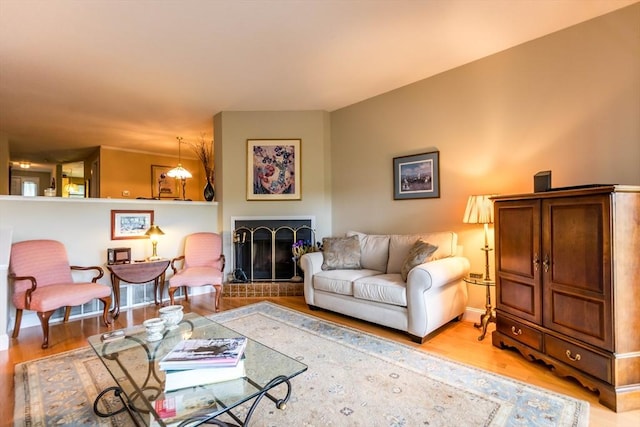 living area with light wood-style floors and a fireplace with raised hearth