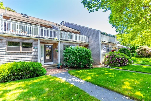 townhome / multi-family property with a balcony and a front yard