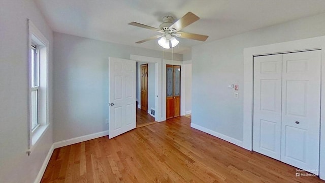 unfurnished bedroom featuring ceiling fan, visible vents, baseboards, a closet, and light wood finished floors
