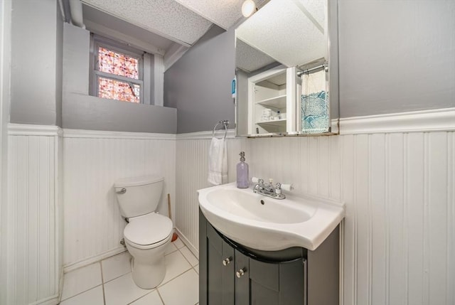 full bath featuring tile patterned floors, toilet, wainscoting, and vanity