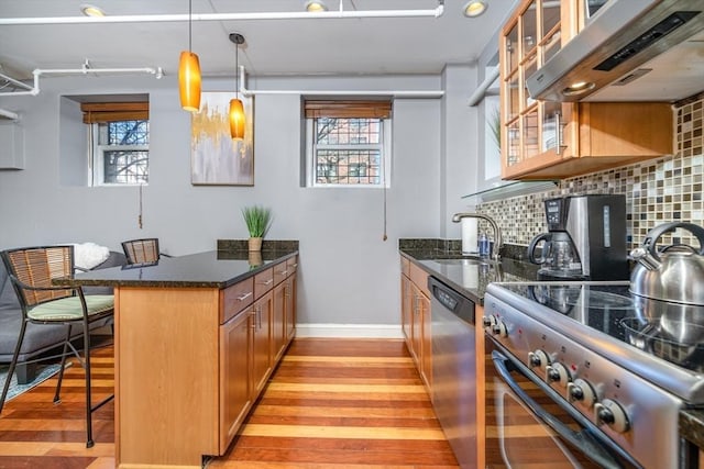 kitchen featuring range hood, a sink, stainless steel dishwasher, electric range oven, and brown cabinets