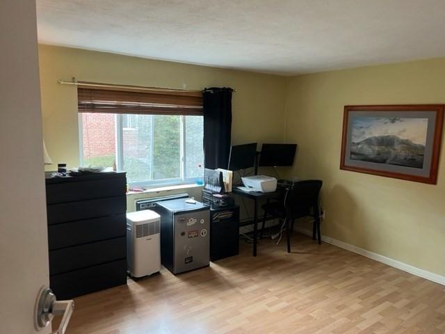 home office with baseboard heating and light hardwood / wood-style flooring