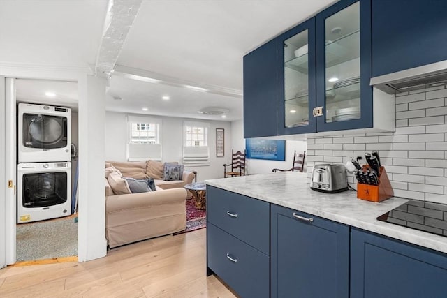 166 Water St Unit 166, Newburyport, MA 01950 - kitchen with estacked washer and dryer, blue cabinetry, light countertops, backsplash, and recessed lighting